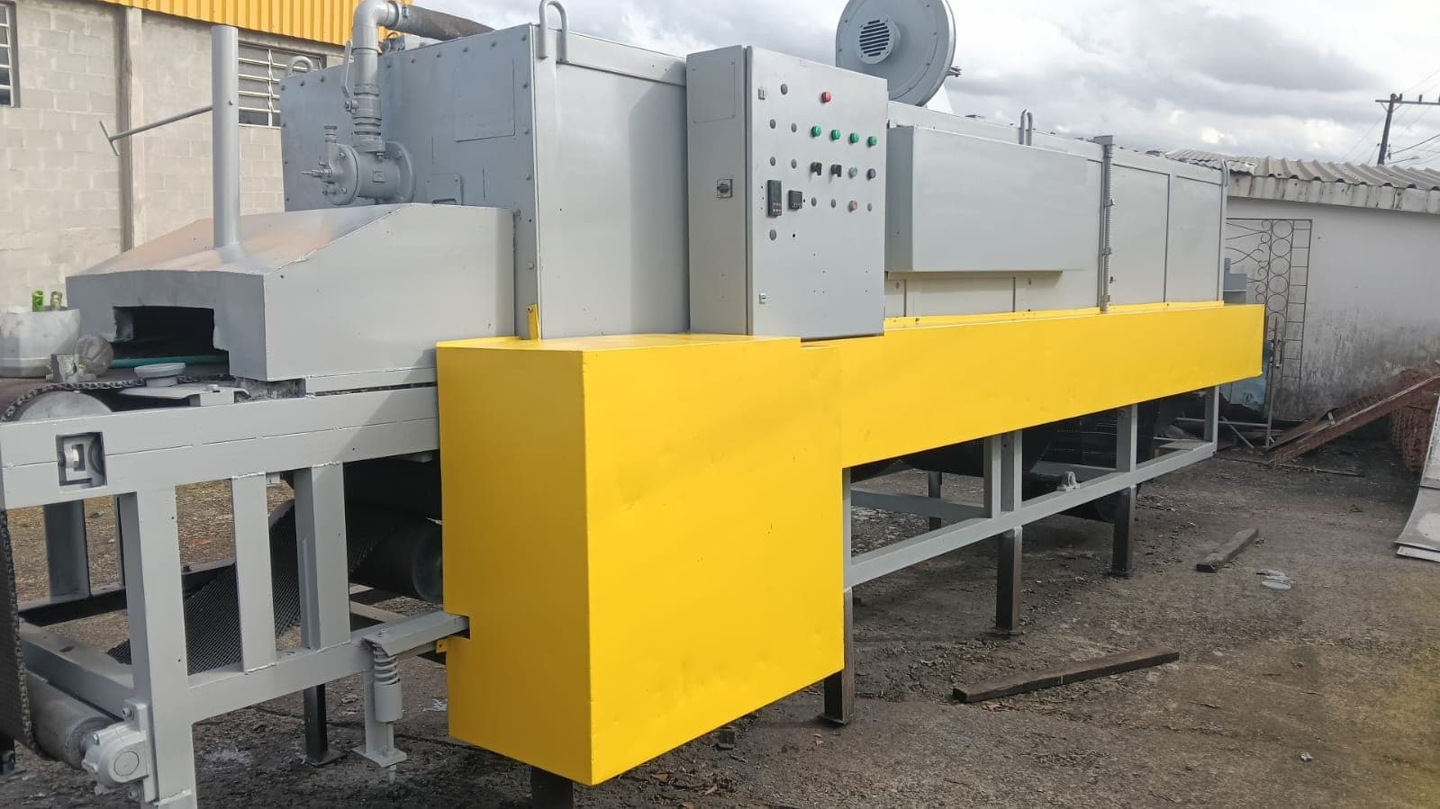 Forno industrial de esteira com painel de comando elétrico e proteções amarelas
